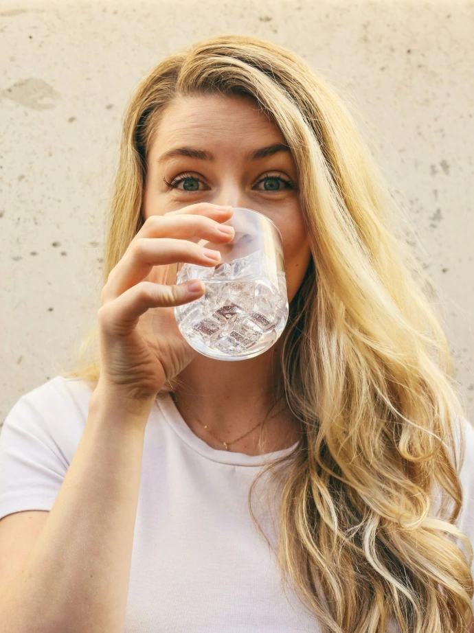 Femme qui boit un verre d'eau purifiée