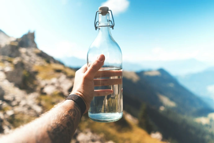 Bouteille d'eau tenue en main dans la nature